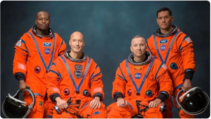 Artemis 3 crew portrait: Andre Douglas, Luca Parmitano, Randy Bresnik and Frank Rubio in orange NASA spacesuits at Johnson Space Center, June 2026